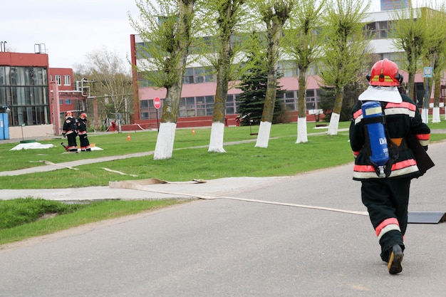 Professional firefighters rescuers in protective fireproof suits helmets and gas masks with oxygen