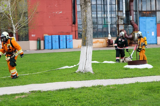 Professional firefighters rescuers in protective fireproof suits helmets and gas masks