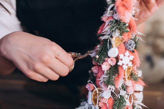 Professional florist makes bouquet of flowers and new year and christmas decoration