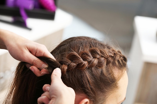 Professional hairdresser braiding clients hair