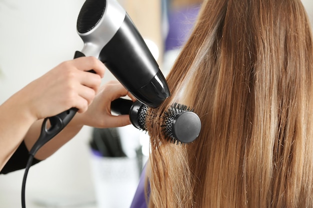 Professional hairdresser working with client in salon