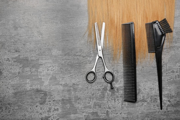 Professional hairdressers set and blonde hair on grey background