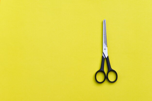 Photo professional hairdressing scissors on yellow background