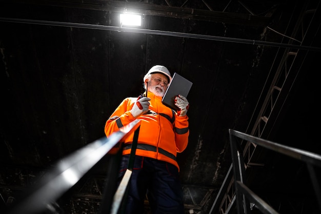 Professional heavy industry engineer worker using tablet computer controlling production