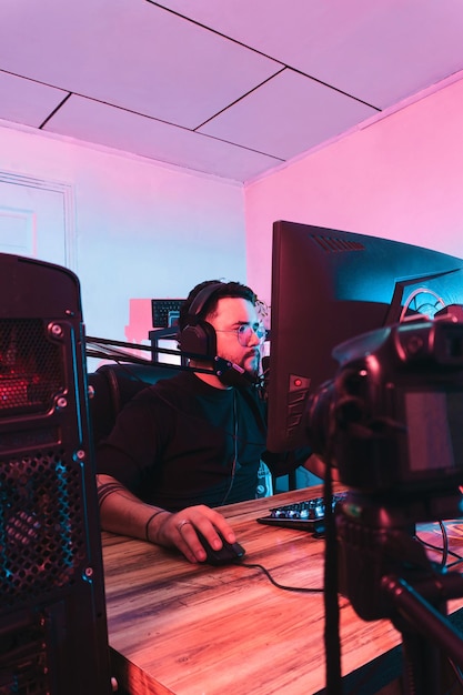 Professional hispanic gamer with headphones and a microphones making a streaming live