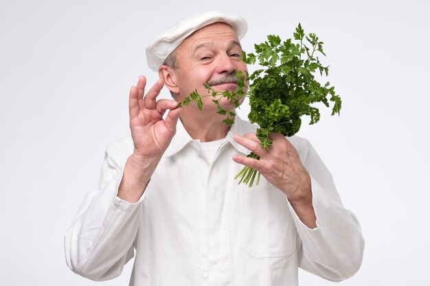 Foto lo chef professionista ispanico maturo del cuoco tiene la vegetazione dell'insalata