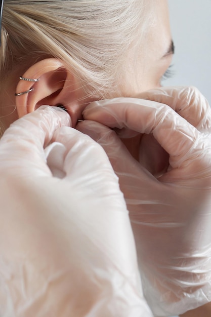 Professional holding the jewel of piercing day just before screw the ball tragus type