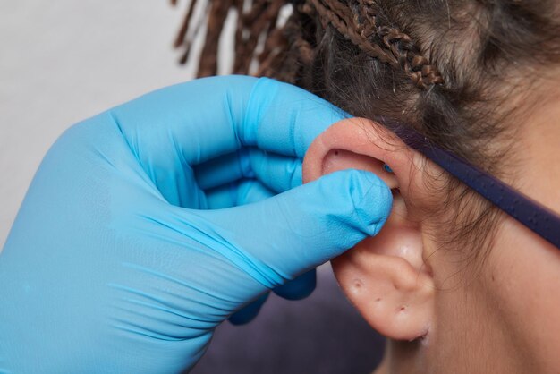 Photo professional holding the jewel of piercing day just before screw the ball tragus type