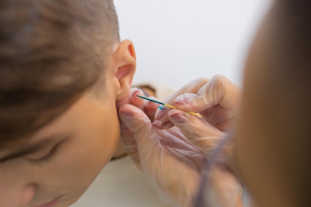 Professional holding the jewel of piercing just before screw the ball