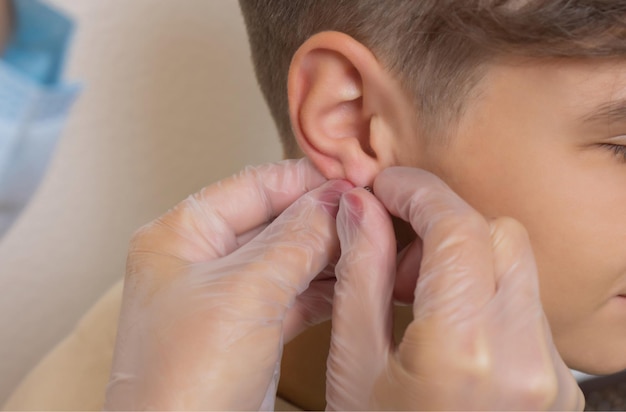 Professional holding the jewel of piercing just before screw the ball