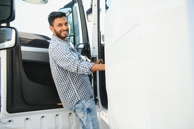 Foto autista di camion indiano professionista che entra nel suo veicolo lungo camion amare il suo lavoro servizi di trasporto