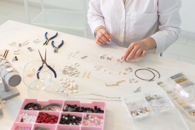 Professional jewelry designer making handmade jewelry in studio workshop close up. Fashion, creativity and handmade concept