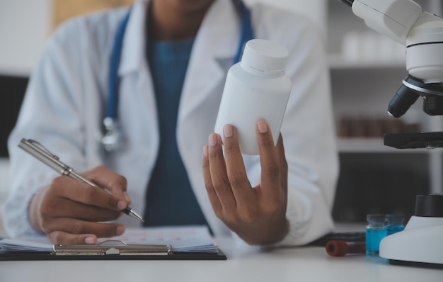 Professional lab Amazing longhaired medical worker wearing uniform while using microscope during research