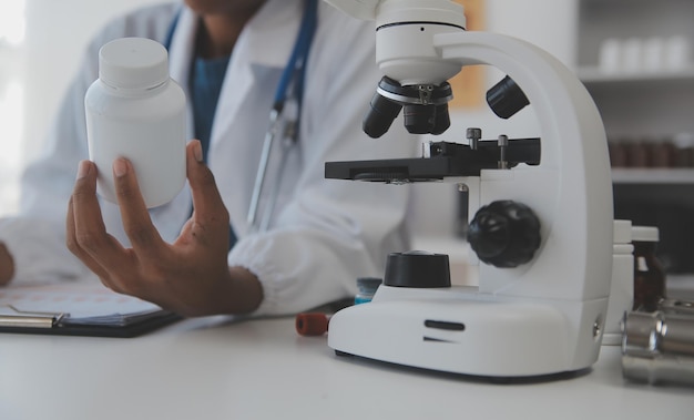 Professional lab Amazing longhaired medical worker wearing uniform while using microscope during research