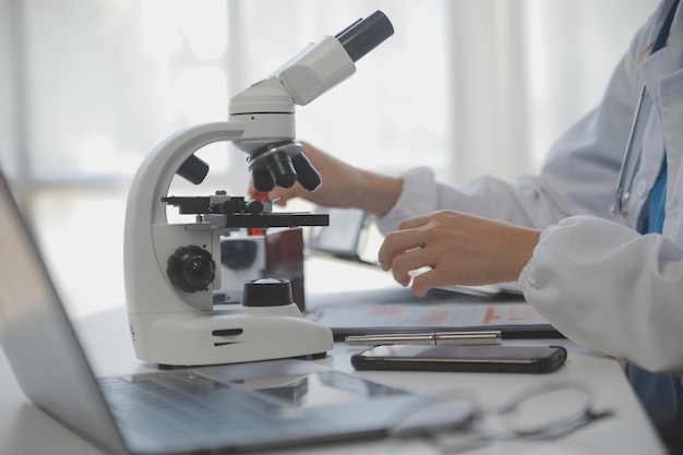 Professional lab Amazing longhaired medical worker wearing uniform while using microscope during research