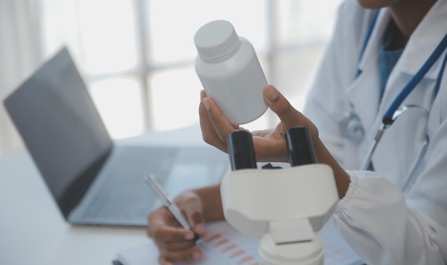 Professional lab Amazing longhaired medical worker wearing uniform while using microscope during research