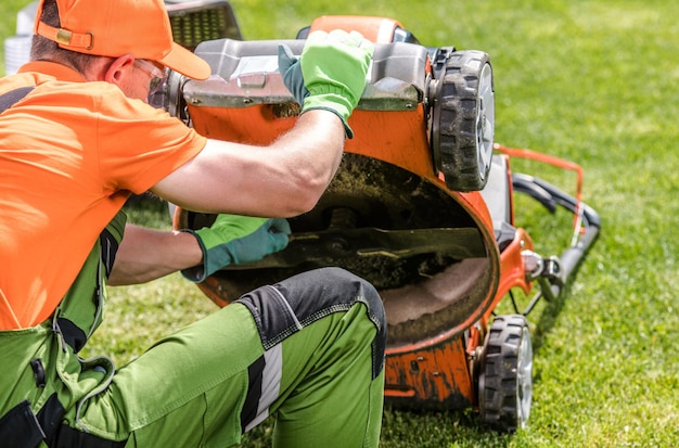 Photo professional landscaper checking on lawn mower blade