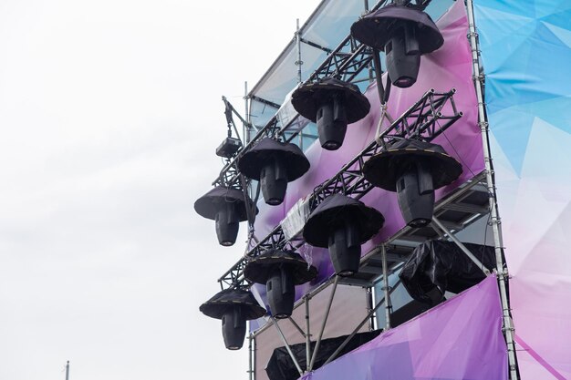 Профессиональное световое оборудование высоко над концертной сценой под открытым небом