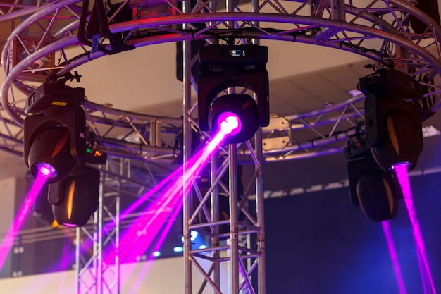 Фото Профессиональные осветительные приборы с вращающейся головкой подвешены на столбе по кругу для сценической платформы.