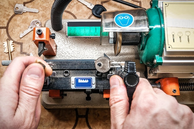 Professional locksmith makes a duplicate key with special machine