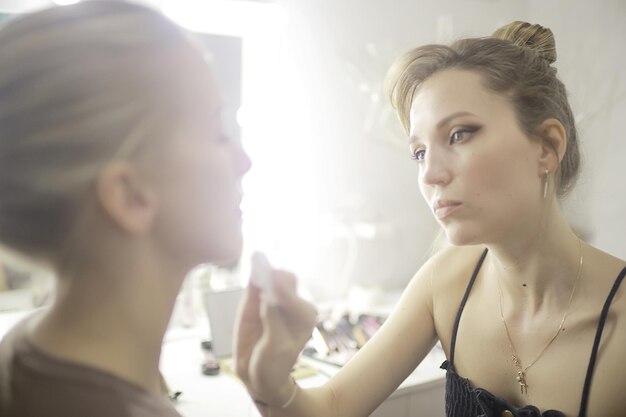 professional make-up in the beauty salon / master makes a professional fresh summer make-up of a beautiful model in the salon