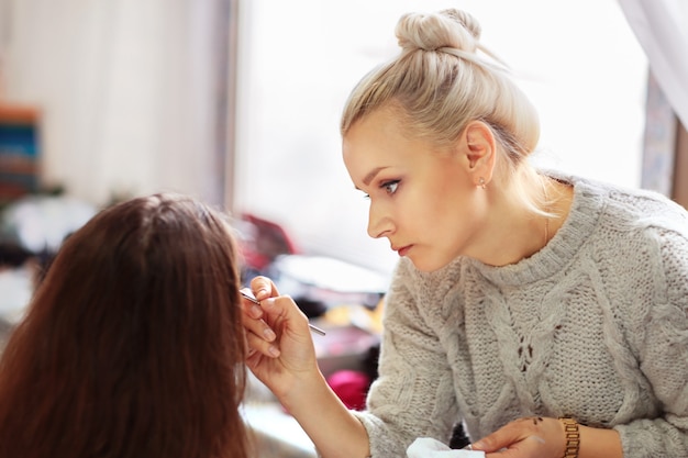 Professional makeup artist apply makeup beautiful girls for the holiday.