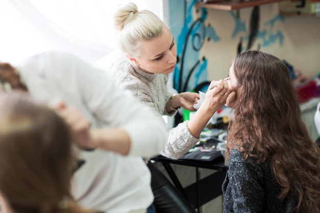 Professional makeup artist doing makeup for client's salon