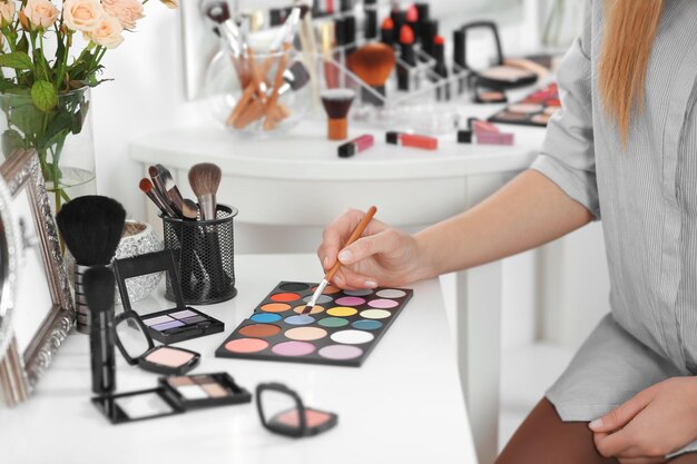 Professional makeup artist with cosmetics at beauty salon