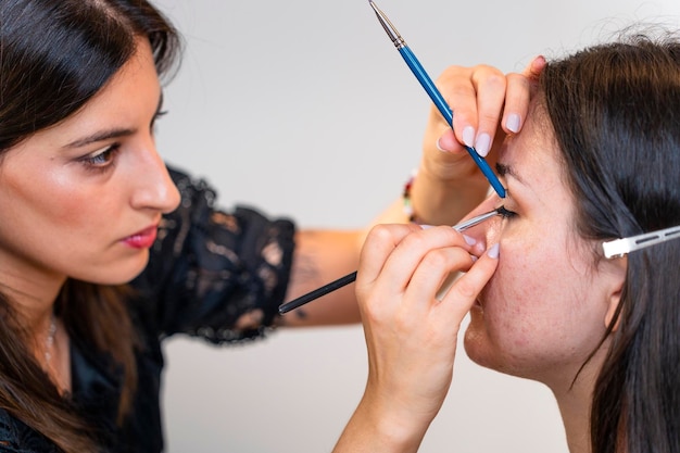 Professional makeup artist working the eye of a young woman