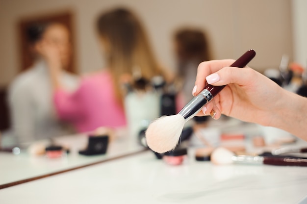 Professional makeup brush in hands of stylist