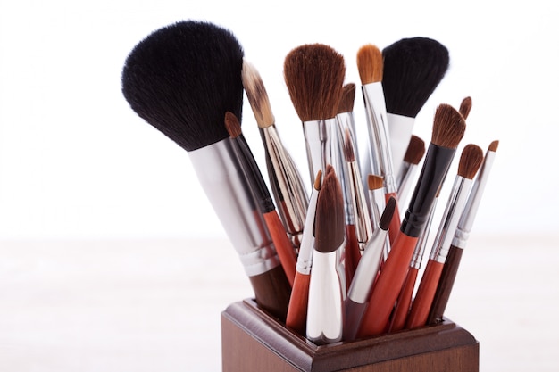 Professional makeup brush on white wooden background