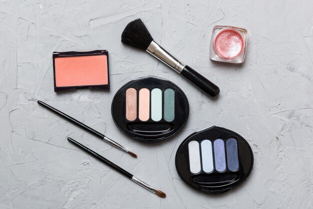 Foto strumenti di trucco professionali top view flat lay beauty cosmetica decorativa set di pennelli di trucco e palette di ombra per colori sullo sfondo del tavolo stile minimalista