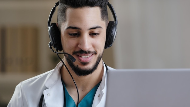 Professional male arab hispanic young doctor assistant in medical coat wear headset with microphone