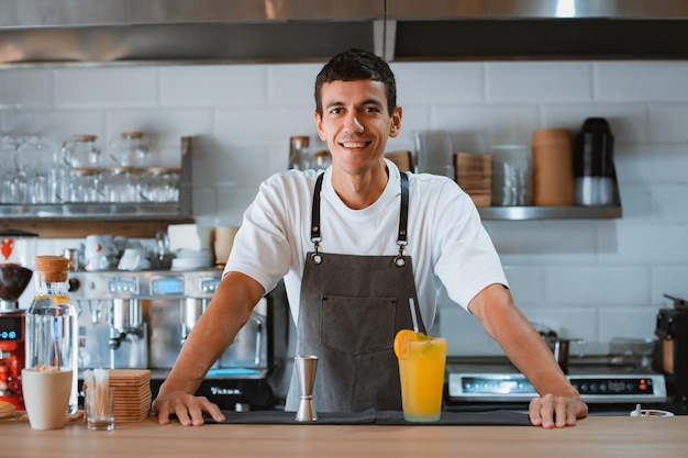 Professional male barista making caramel iced frappe while working in local coffee shop