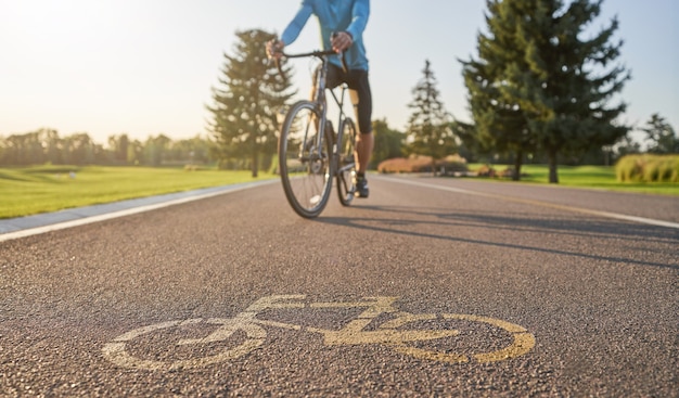 Professional male cyclist riding a road bike on a cycle path in\
the background.