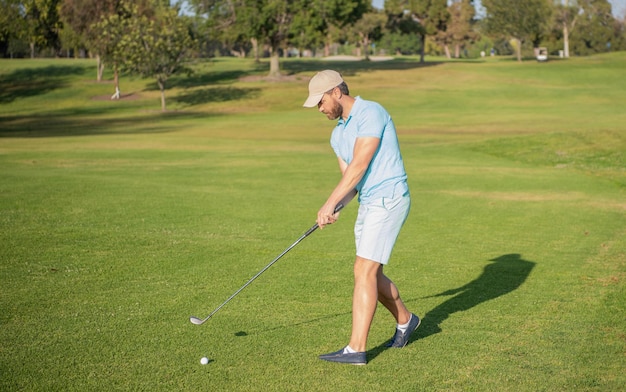 Professional male golf player on professional course with green\
grass, summer