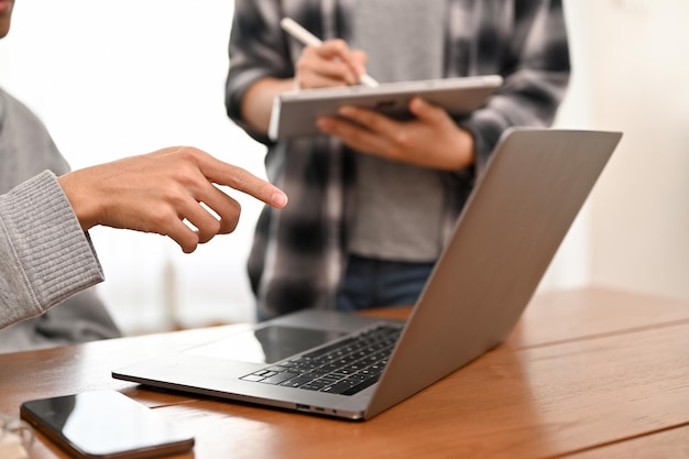 A professional male programmer working with his assistant in the office cropped image