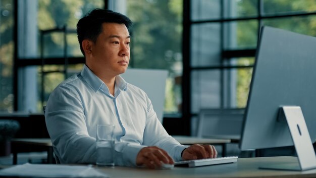 Professional male worker korean successful businessman programmer specialist sit at office desk