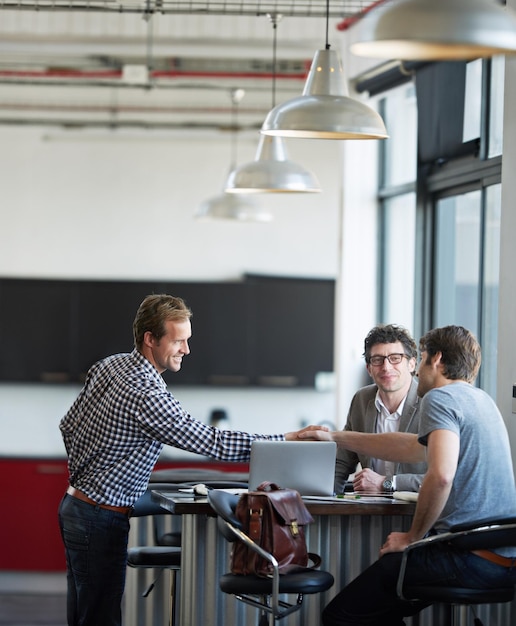 professional man partner and handshake with team in office for meeting creative and company startup men collaboration and business deal in modern workspace for agency strategy and design