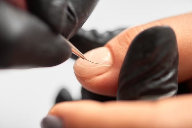 Professional master manicurist working on client fingernails