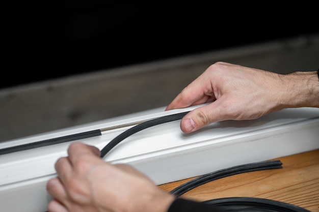 Professional master at repair and installation of windows, changes rubber seal gasket in pvc windows