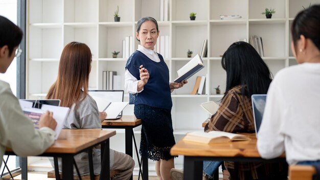 Photo a professional mature asian female teacher teaching in the classroom giving a lecture