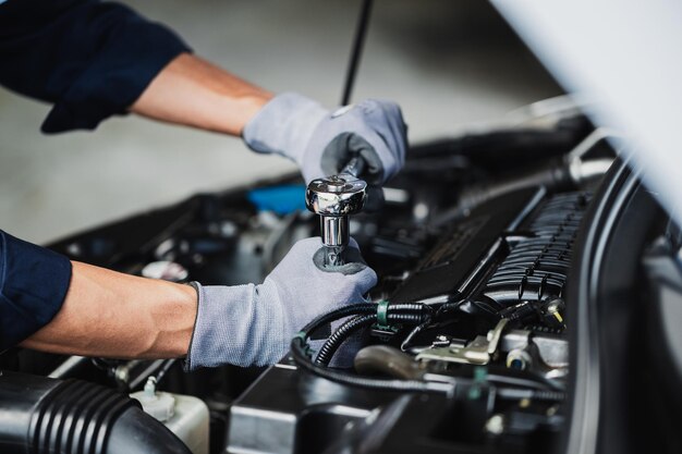 Professional mechanic working on the engine of the car in the\
garage car repair service