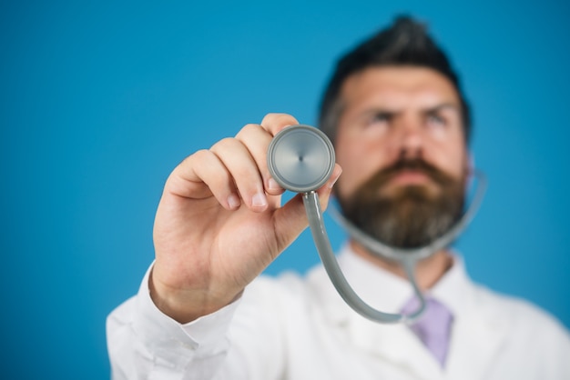 Professional medical bearded doctor with stethoscope in hand doctor holds in his hand stethoscope