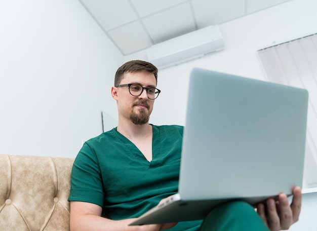 컴퓨터를 사용하는 전문 의료 전문가 노트북으로 작업하는 잘생긴 젊은 의사