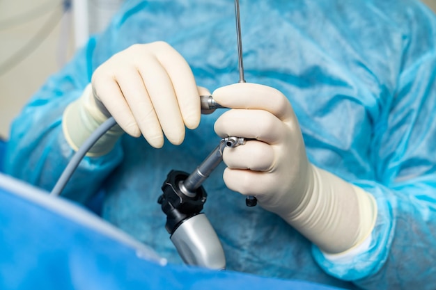 Professional medical specialist working with instruments Surgeon in blue uniform working with equipment