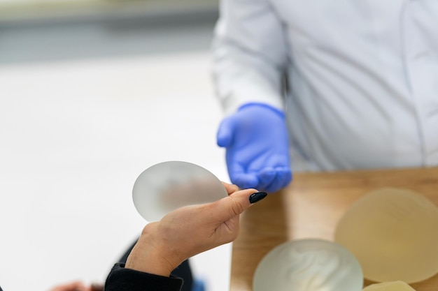 Professional medical worker showing new implants for woman beauty Doctor surgeon in modern hospital Close up