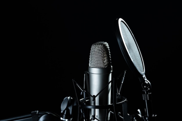 Professional microphone against black background in studio