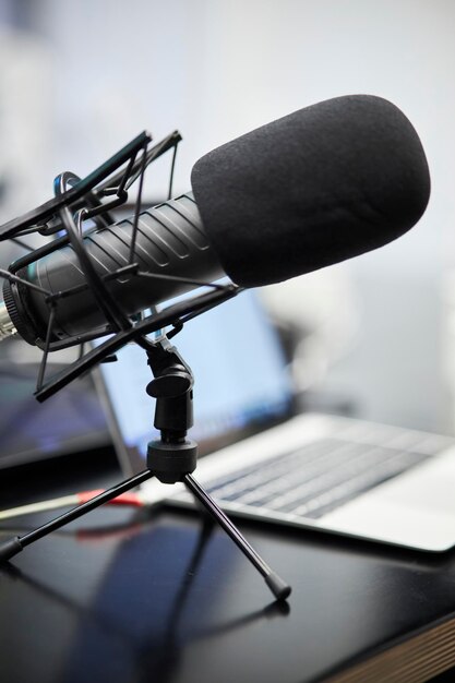 a professional microphone for recording a podcast and a laptop on the table