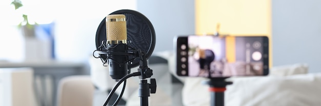 Professional microphone standing near video camera closeup home video recording studio concept